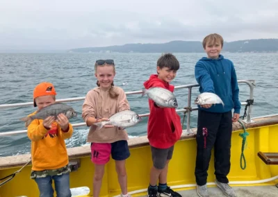 4 Kids with their bream caught while on a boat trip in Lyme Regis